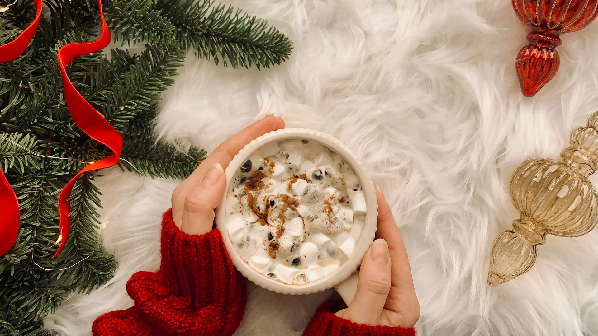The primary purpose of this image is to evoke a warm, cozy, and festive winter holiday atmosphere, specifically centered around the experience of enjoying a hot beverage.
